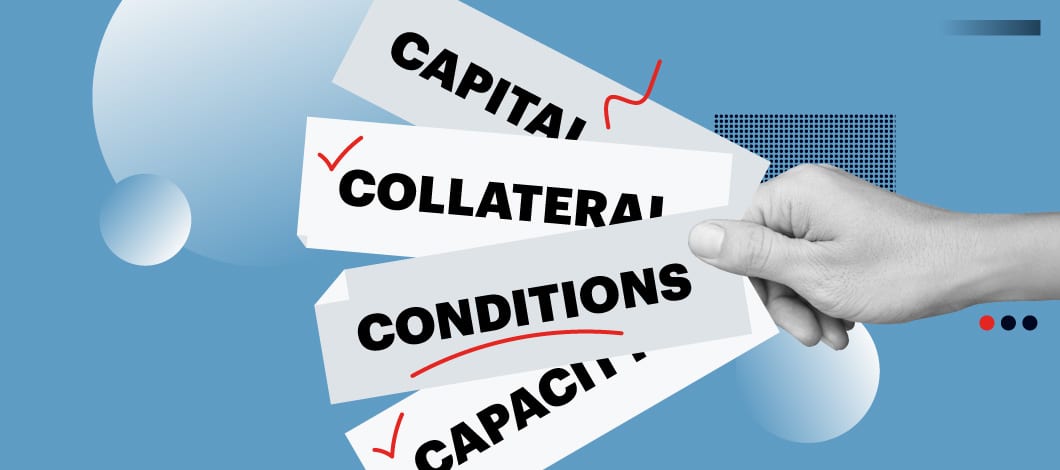 A hand holds pieces of paper labeled “Capital,” “Collateral,” “Conditions” and “Capacity.”