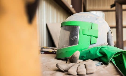 Photo of a green work helmet and white work gloves
