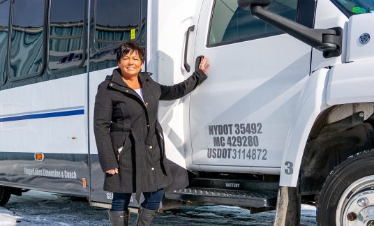 Woman standing next to party bus
