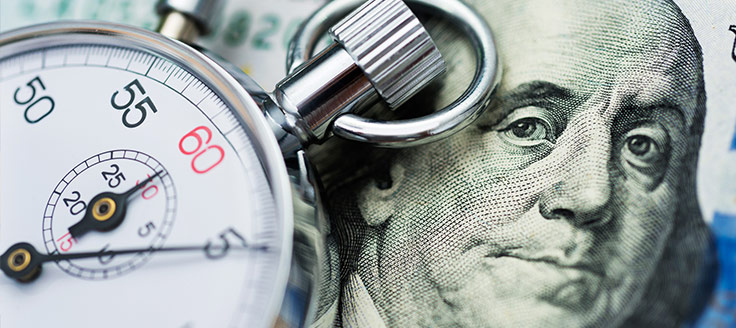 An image of Benjamin Franklin and a stop watch are a reminder of the business tax filing deadline.