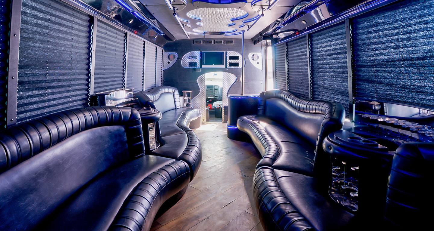 Interior of a shuttle, decorated with curvy leather couches and contemporary overhead lighting.