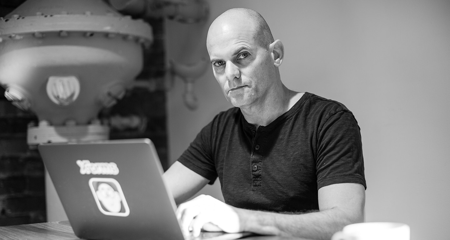 Black-and-white photo of Jim Young seated at a desk with a laptop. 