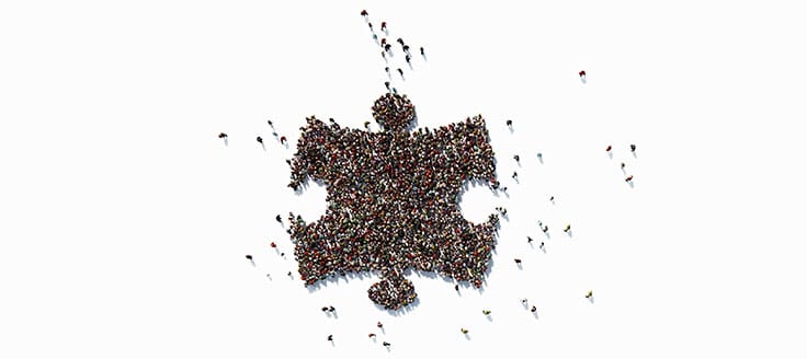 A crowd of people forming a puzzle piece.