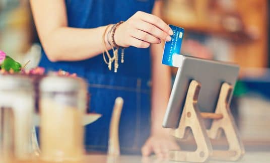 A small business owner puts a credit card payment through Square hardware. Stripe vs. Square: Which is best for your small business?