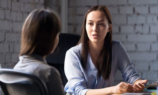 Female advisor consulting small business owner at a meeting.