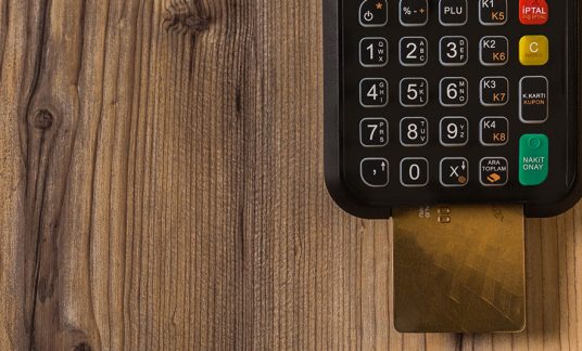 Credit card processing reader on the countertop with the card inserted. 