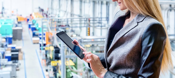 A businesswoman oversees a warehouse facility as she works on a tablet. You can access your Yelp business account through a mobile app.