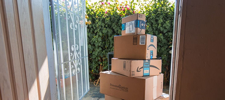 Several Amazon shipments stacked outside someone's front door