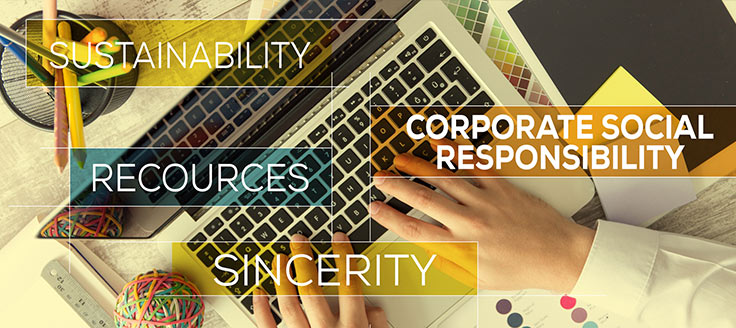 Hands typing on a keyboard and a business article sitting on a desk with the words "Ethics" and "Corporate Social Responsibility" in an overlay. 