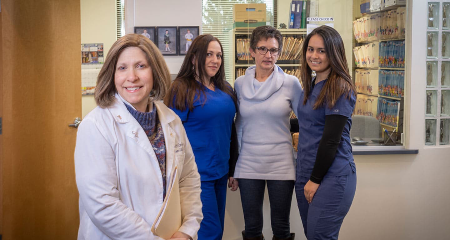 Eileen Conti, M.D. standing before her team