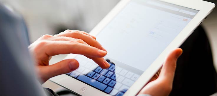 A businesswoman checks her Gmail business account on her tablet.