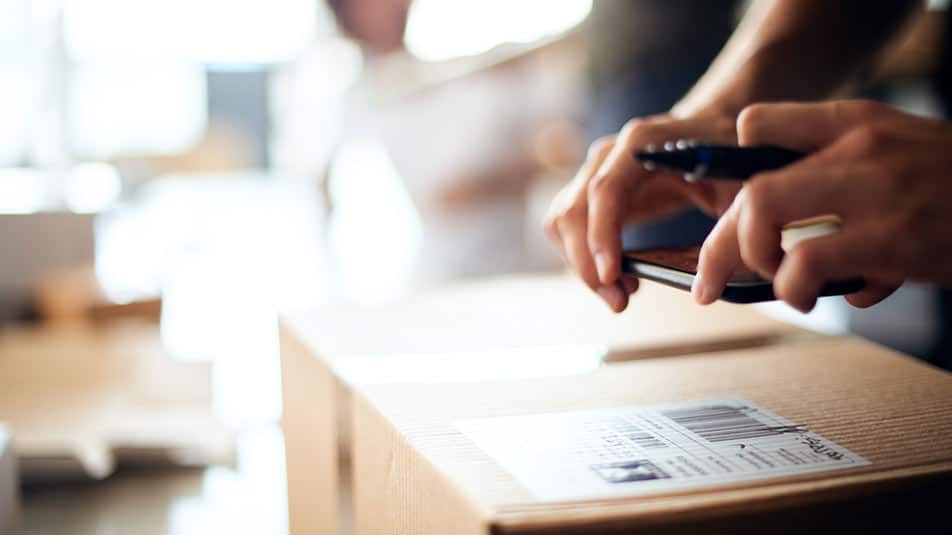 A person gets a package ready for shipping.