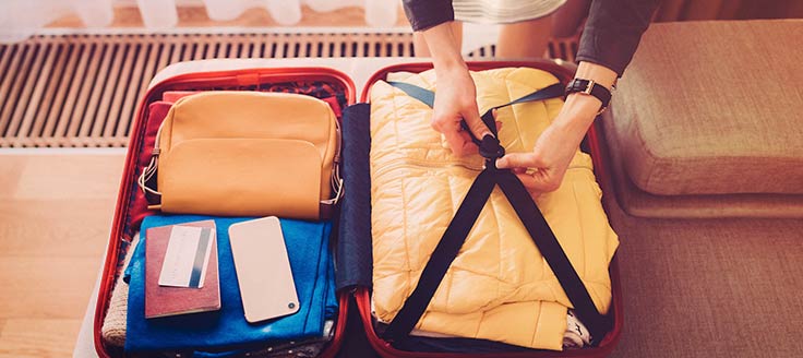 A woman packs a suitcase. A Chase business credit card that offers airline miles and other perks would benefit a business that requires regular travel.