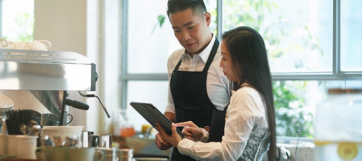 Two cafe employees consult a tablet. When you run a business, generating revenue is a main goal. Your business assets — fixed or not — should contribute value and grow revenue.