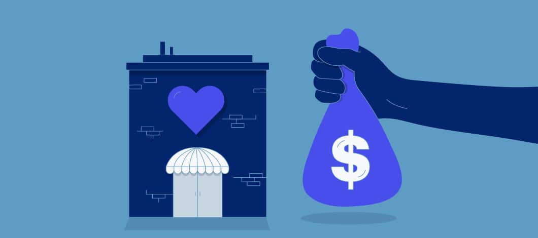 Hand holding a bag of money in front of a store with a heart on it