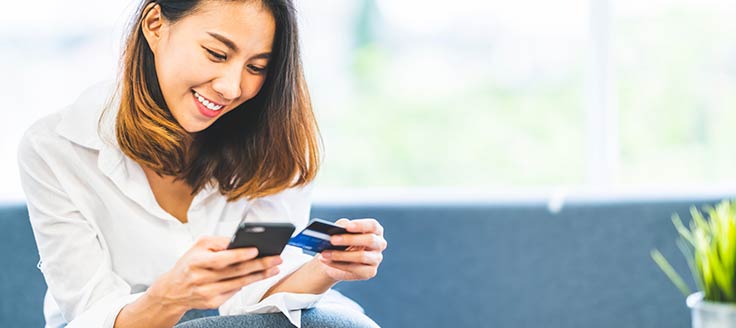 A young woman shops from her mobile phone. M-commerce is one of the top business trends for 2020.