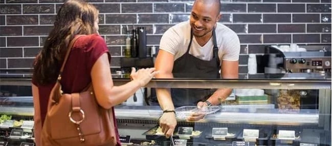 A man scoops food for a woman's deli lunch. Business expansion to another location can help you improve customer service.