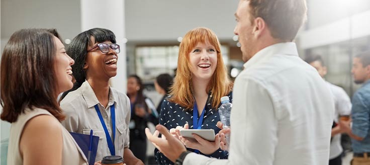 Attendees of a business expo network with each other.