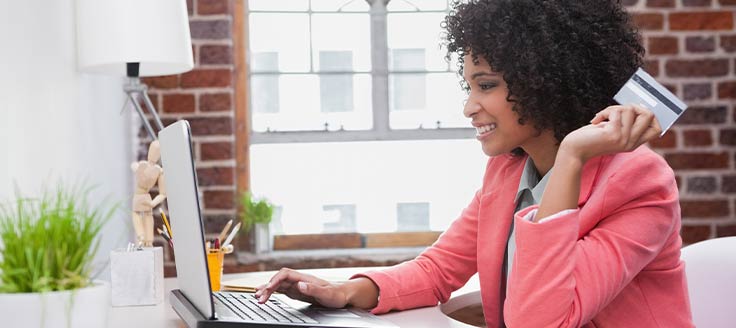 A businesswoman uses a credit card to make online purchases for her company.