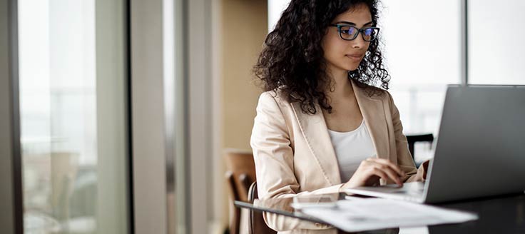 A businesswoman works on her laptop at a coffee shop.