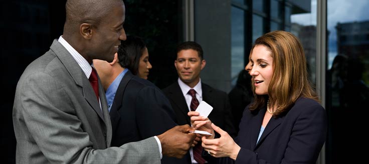 Business people exchange business cards at a networking event.