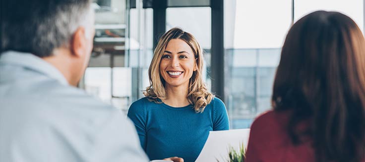 A woman smiles at her customers. Being positive can help you handle an upset customer.