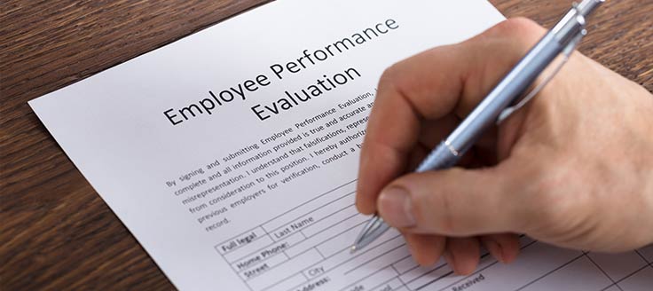 A person fills out an employee performance review document.