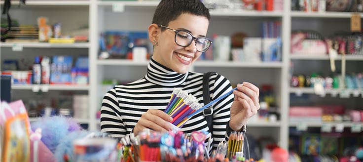 A woman shops for stationery supplies. Your business’s office supply purchases could help you obtain credit card rewards.