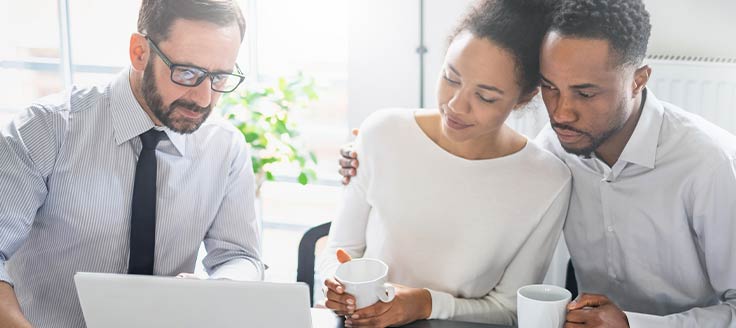 A couple review the terms of a low-interest loan with their financial adviser.