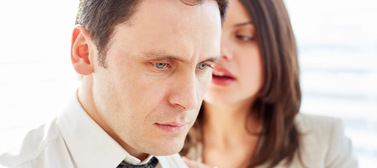 A woman sexually harassing a male coworker in the workplace. 