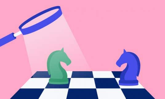 A magnifying glass inspects a chess board with two opposing knights.