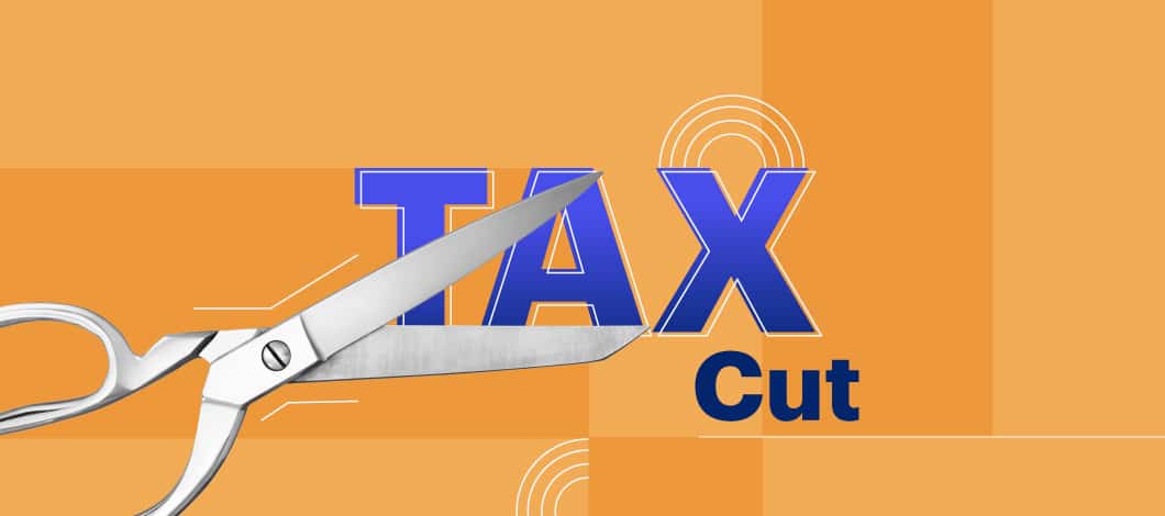 A pair of scissors prepares to cut the words “Tax Cut.”