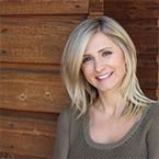 A smiling Diana Venckunaite with a wooden slat backdrop