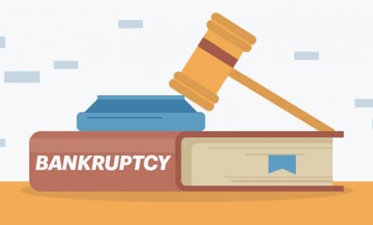 A gavel and block rest on a big book labeled “Bankruptcy.”