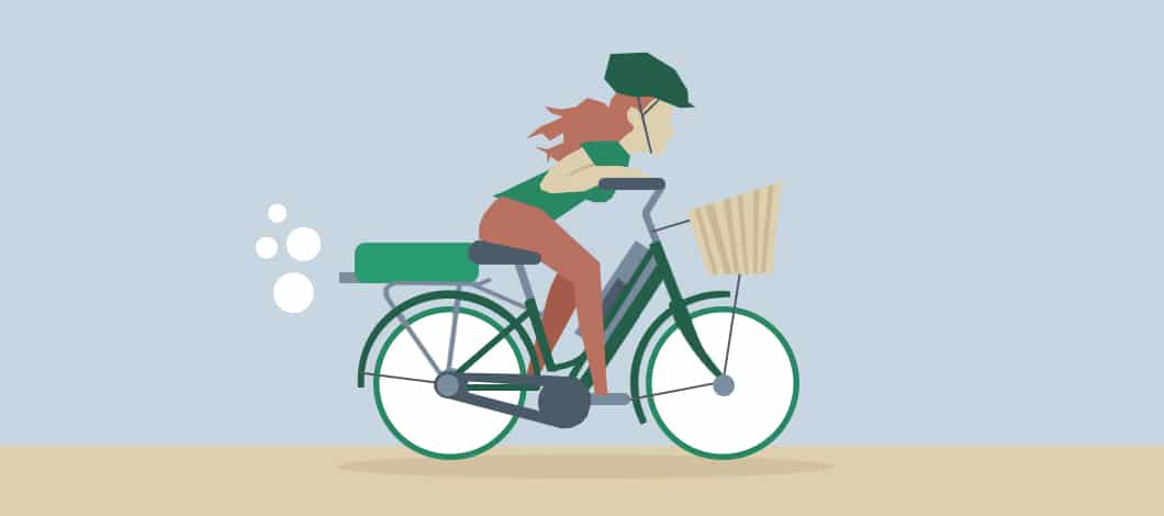 An employee rides an ebike to work. She is wearing a bike helmet.