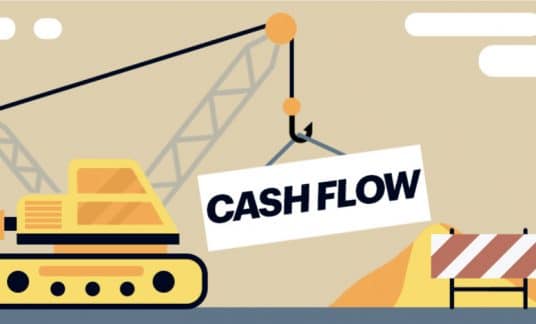 A crane lifts the words “Cash Flow” at a construction site.