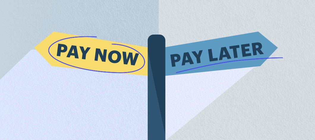 One sign reads “Pay Now” and points in one direction. The other sign, pointing in the opposite direction, reads “Pay Later.”