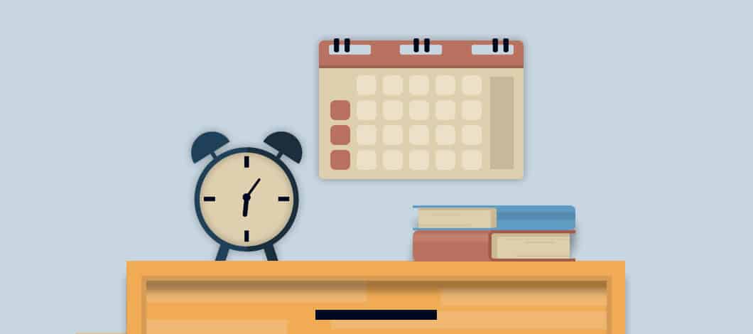An alarm clock sits near a calendar hanging on a wall.
