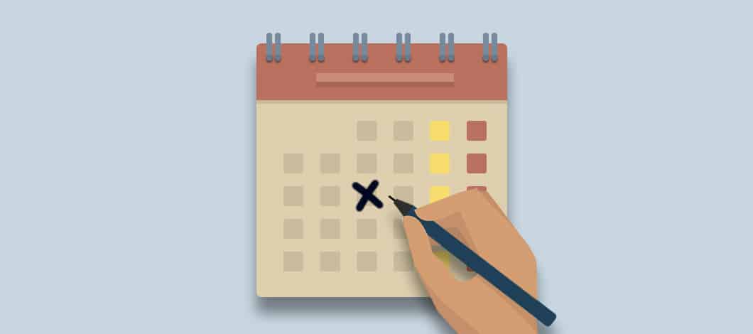A hand with a pen marks off a day on a calendar.