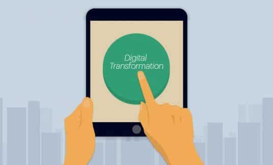 A finger is about to press a green circle on a computer tablet touch screen that is labeled “Digital Transformation.”