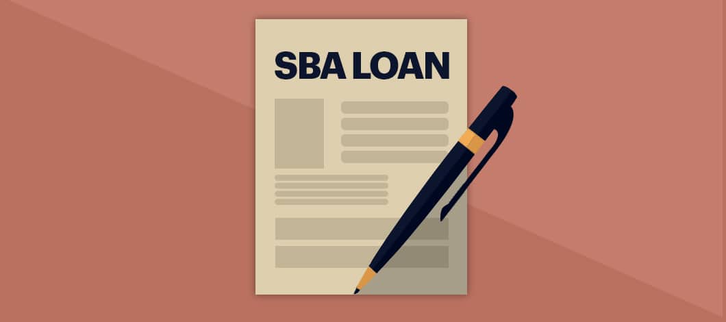 A pen rests on a blank application form labeled “SBA Loan.”