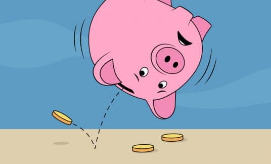 Upside down pink piggy bank with coins falling out