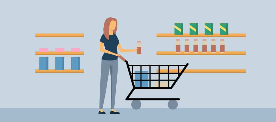 A woman in a grocery store places an item into a shopping cart.