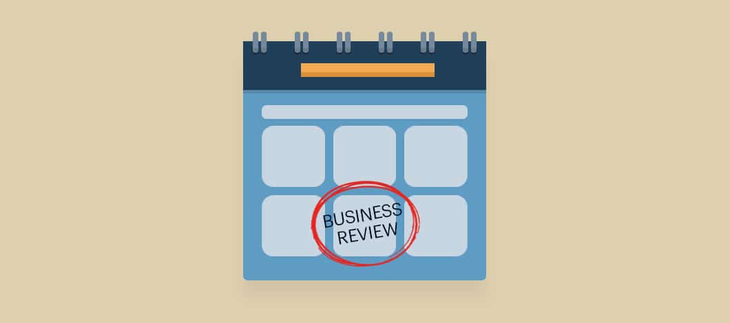A calendar hangs on the wall. A date is circled in ink with the note, “Business Review.”