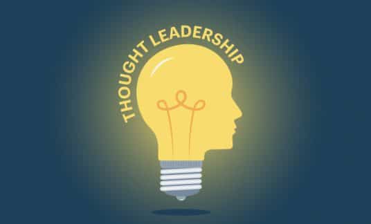 A light bulb in the shape of a human head glows. The words “Thought Leadership” surround the top of the bulb.