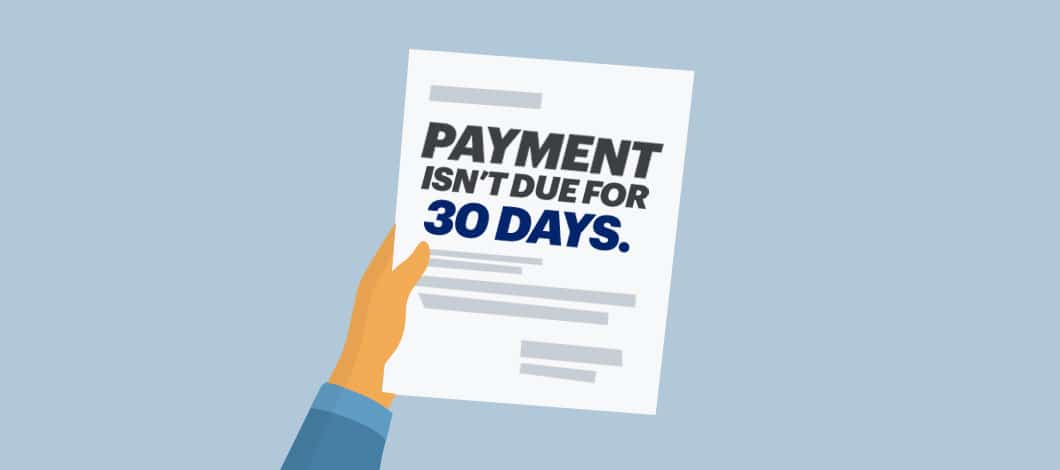 A hand holds a paper notice that reads “Payment Isn’t Due for 30 Days.”